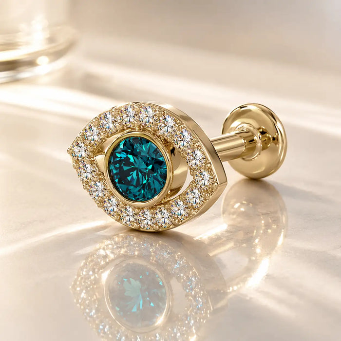 14k yellow gold evil eye flat back stud with blue topaz center and diamond halo, angled lifestyle shot