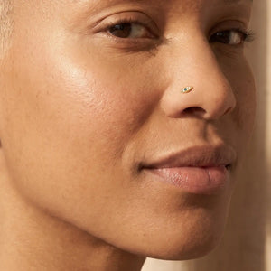 Model wearing the Evil Eye Diamond Nose Ring in 14k gold in a nostril piercing
