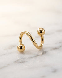Spiral barbells - 14k yellow gold twister spiral barbell on white marble