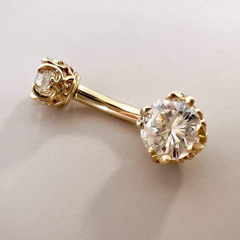 Close-up of 14k yellow gold belly ring highlighting 5mm VS1 diamond in ornate filigree prong setting