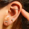 Insertion tool being used in a helix piercing on a model, with gold CZ chain connector studs in lobe
