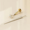 Flat back earring insertion tool beside a gold CZ flat back stud, showing tool and jewelry separately