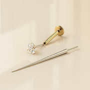 Flat back earring insertion tool beside a gold CZ flat back stud, showing tool and jewelry separately