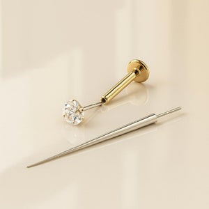 Flat back earring insertion tool beside a gold CZ flat back stud, showing tool and jewelry separately