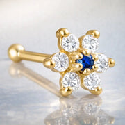 14K yellow gold flower nose bone with deep blue sapphire CZ center and clear CZ petals, angled view
