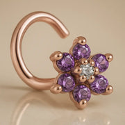 14K rose gold flower nose twist with purple CZ petals and clear center stone, angled view