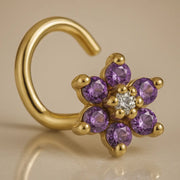 14K yellow gold flower nose twist with purple CZ petals and clear center stone, angled view