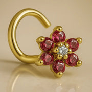 14K yellow gold flower nose twist with red CZ petals and clear center stone, angled view