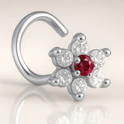 14K white gold CZ flower nose ring twist with red center CZ, angled view on warm background