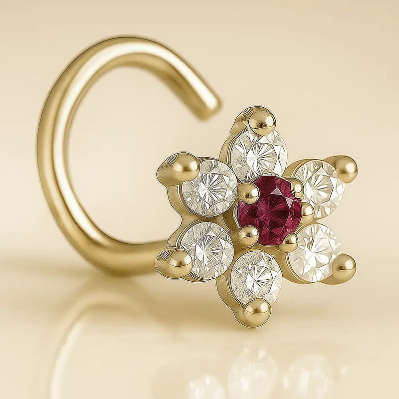 14K yellow gold CZ flower nose ring twist with ruby-red center CZ, angled view on beige background