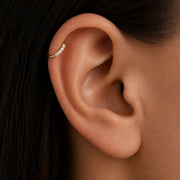 Four-diamond 14K gold seam ring hoop shown in a helix piercing, demonstrating side-set fit