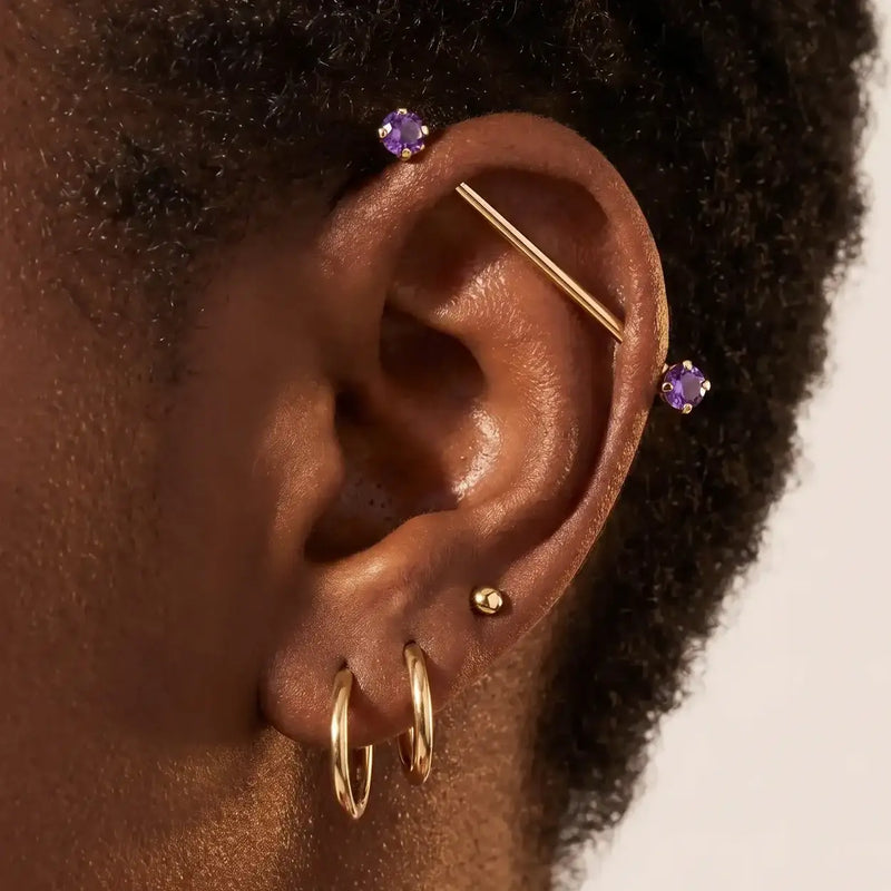 Model wearing a 14K gold gemstone Industrial Barbell in an ear industrial piercing - shown for size and placement