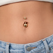 14k gold double ball belly ring shown in navel piercing on model wearing denim jeans