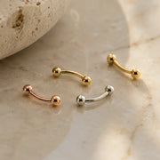 Solid 14k gold curved barbell belly and eyebrow rings lifestyle photo
