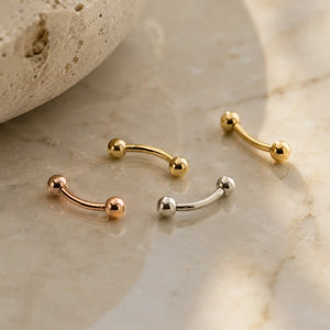Solid 14k gold curved barbell belly and eyebrow rings lifestyle photo