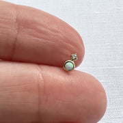 14k gold opal and diamond threadless stud end held on fingertip for actual size reference