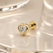14k yellow gold diamond heart flat back stud on reflective surface, angled lifestyle shot