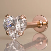 14k rose gold flat back labret with prong-set heart CZ, angled studio shot with reflective surface