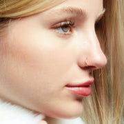 14k gold 20G seam ring worn in nostril piercing, side profile showing minimalist fit