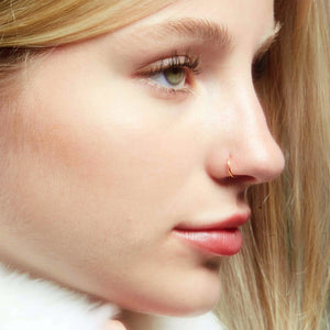 14k gold 20G seam ring worn in nostril piercing, side profile showing minimalist fit