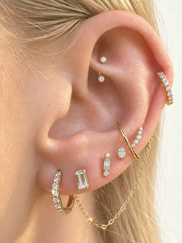 Curated ear stack of 14k gold and diamond studs, hoops and a chain