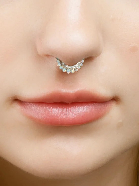 Opal septum clicker worn in a septum piercing