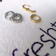 14k yellow gold plain huggie hoops shown alongside CZ white gold hoops for size comparison