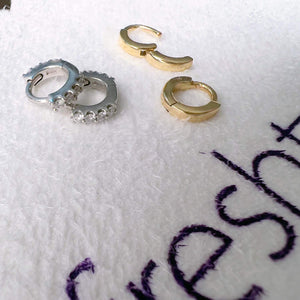 14k yellow gold plain huggie hoops shown alongside CZ white gold hoops for size comparison