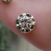 Close-up of 2.5mm VS1 diamond illusion setting in gold shown in a piercing on model's ear