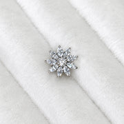 A diamond flower shaped stud, displayed on a white textured velvet ring stand.