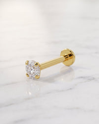 Diamond lip rings - 14k yellow gold low-set prong diamond flat back stud on white marble