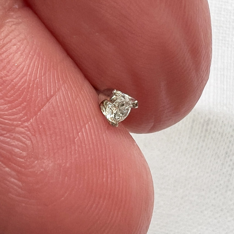 Side profile of 3-prong VS1 diamond threadless stud end held on fingertip showing low-profile setting height