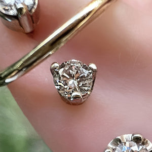 Extreme close-up of 3-prong diamond piercing stud end showing VS1 diamond facets and prong detail