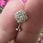 14k white gold diamond halo floating navel ring held between fingers showing size and sparkle
