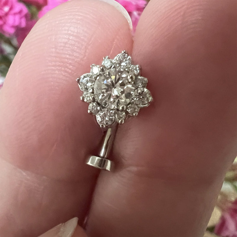 14k white gold diamond halo floating navel ring held between fingers showing size and sparkle