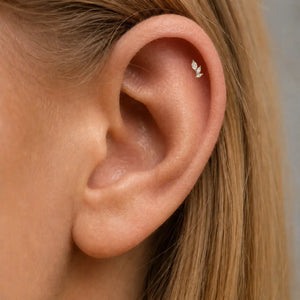 Close-up of an ear with a three  marquise diamonds climber helix piercing earring.