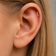 Close-up of an ear with a small marquise and round diamonds climber helix earring