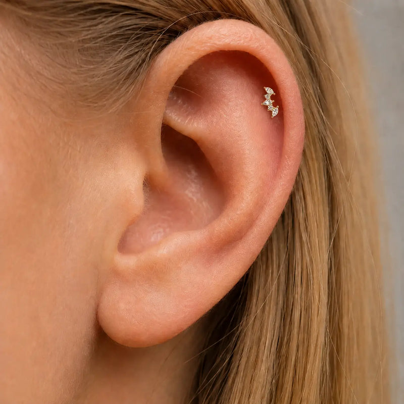 Close-up of an ear with a small marquise and round diamonds climber helix earring