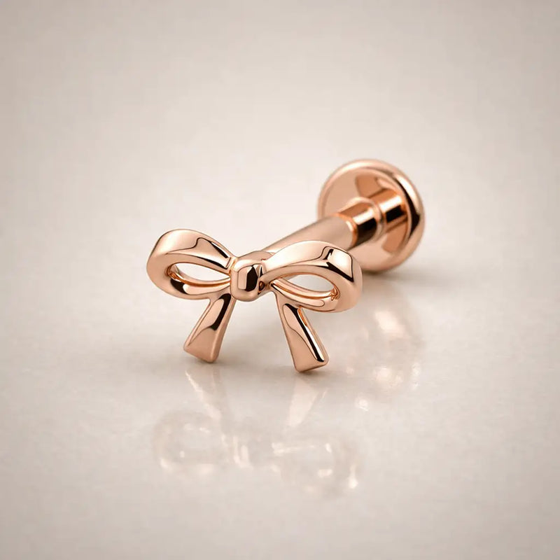 14k rose gold bow flat back labret stud, angled view highlighting warm tone and polished bow detail