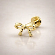 14k yellow gold bow flat back labret stud, angled view showing polished finish and flat disc backing