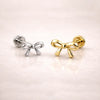 14k yellow gold and white gold bow flat back labret studs side by side, showing size comparison