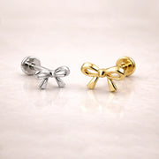 14k yellow gold and white gold bow flat back labret studs side by side, showing size comparison