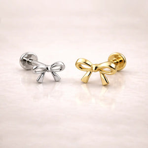 14k yellow gold and white gold bow flat back labret studs side by side, showing size comparison