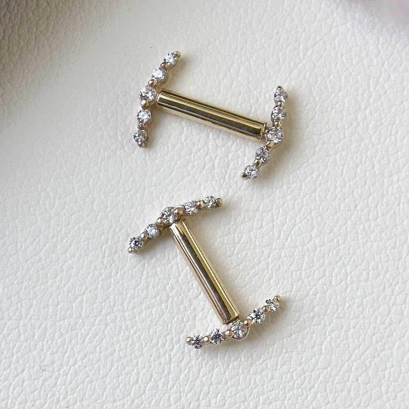 Two 14k yellow gold climber barbell nipple rings laid flat showing size comparison of different lengths