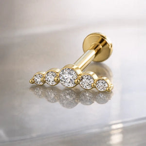 14K yellow gold diamond climber flat back labret on reflective surface, angled view showing 5-stone arc
