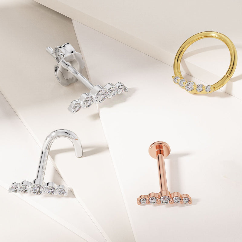 Styled flat lay of 14K gold climber earrings in white and rose gold alongside matching gold hoops