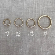 14K yellow gold CZ seam ring shown in four sizes: 18G 1/4", 18G 5/16", 16G 5/16", and 16G 1/2"