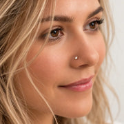 Model wearing a 3mm diamond prong-set nose stud in solid gold, side profile close-up