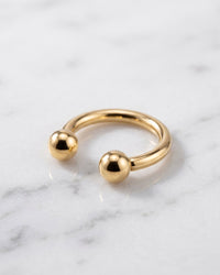 Circular barbells - 14k yellow gold horseshoe circular barbell on white marble