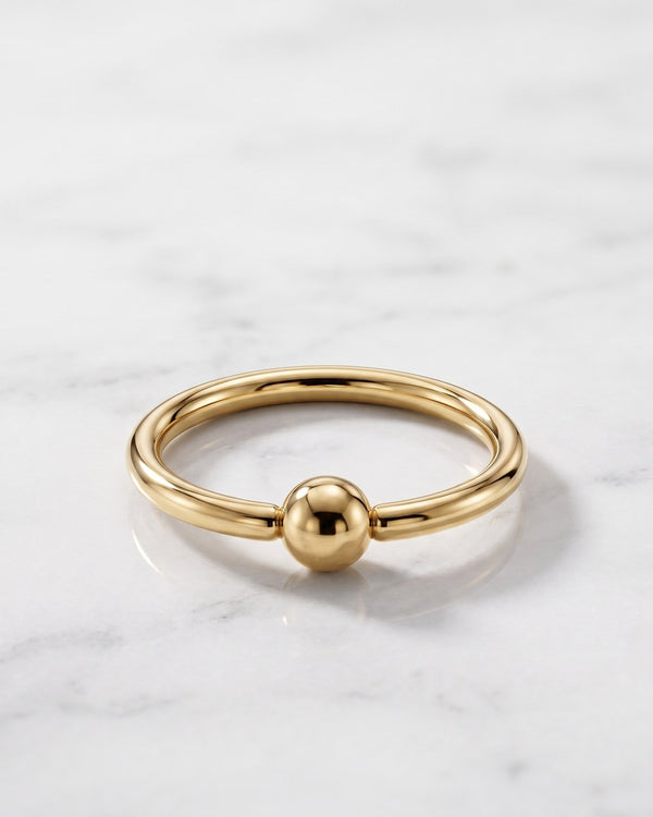 Nipple rings and hoops - 14k yellow gold fixed bead ring on white marble